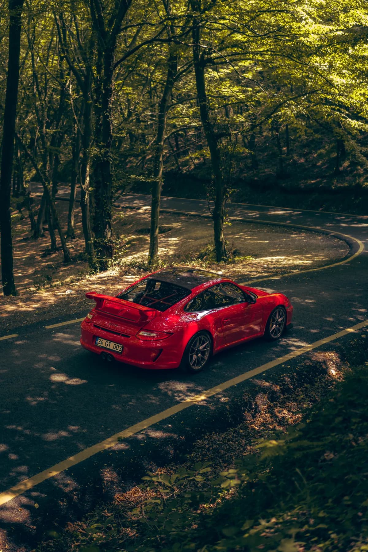 Kırmızı Porsche GT3 orman yolunda kuş bakışı