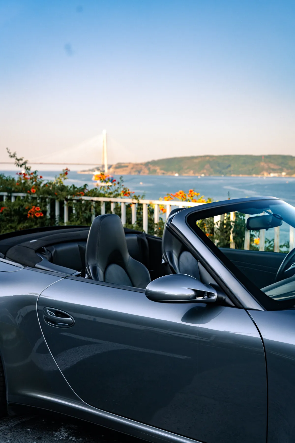 Gümüş Porsche cabrio köprü manzarasında
